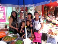 Rosy Look (右边) 和Emily及其家人(Marcia, Rapanui and Takutea) 在巴中市场和一个卖饺子的商人